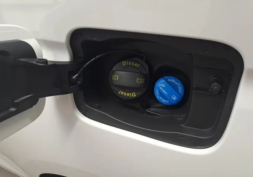 Gros plan sur la trappe à carburant blanche du Volkswagen Caddy Cargo Maxi 2026, avec bouchons diesel et AdBlue visibles.