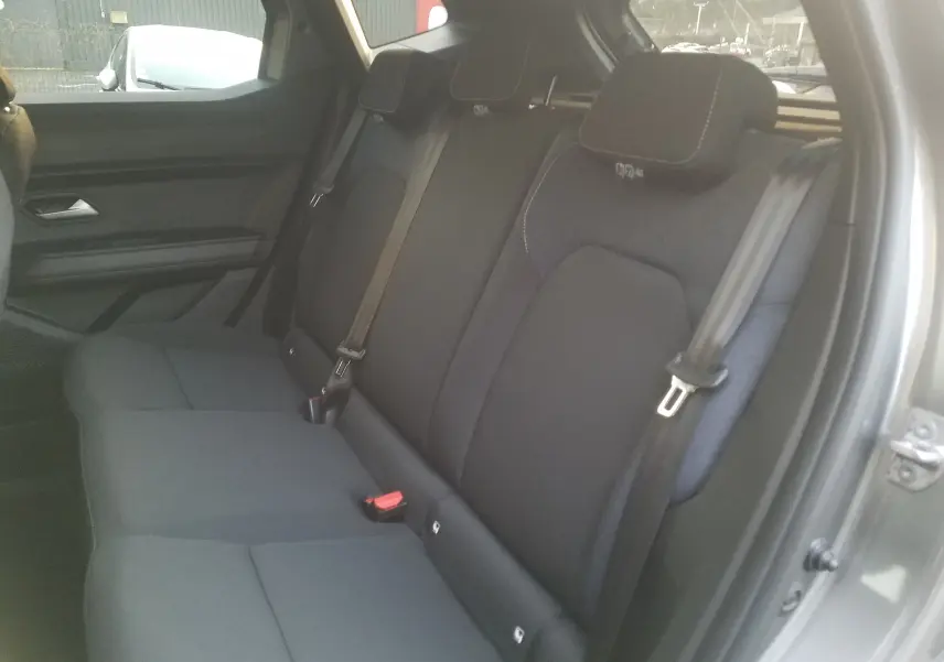 Vue intérieure côté droit des sièges arrière noirs du Dacia Duster 2025 gris schiste avec ceinture de sécurité visible.