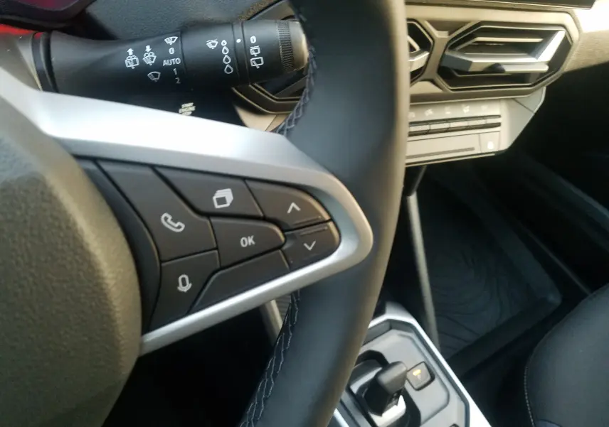 Détail du volant côté gauche du Dacia Duster 2025 avec commandes intégrées et levier de boîte automatique visible.