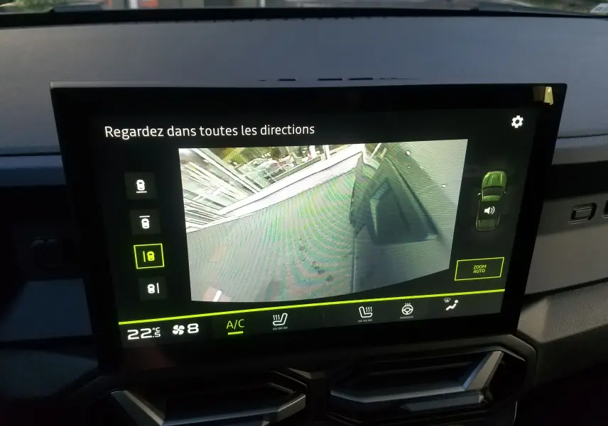 Écran central du Dacia Duster 2025 montrant la caméra de recul avec vue sur un sol gris et un mur blanc.