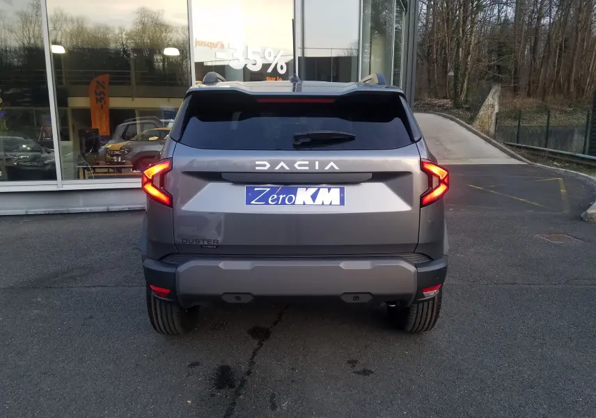 Vue arrière du Dacia Duster gris schiste 2025 avec feux LED en forme de flèche et plaques d'immatriculation "Zero KM".