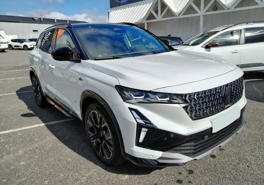 Renault Austral E-Tech blanc nacré avec toit noir, vue 3/4 avant mettant en valeur sa calandre et ses phares LED.