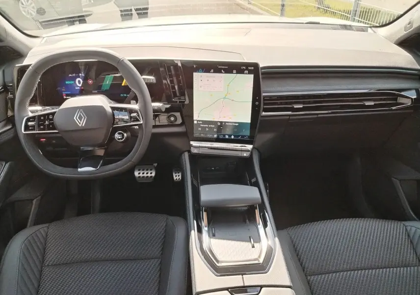 Vue intérieure avant du Renault Austral E-Tech avec tableau de bord numérique et écran tactile central vertical.