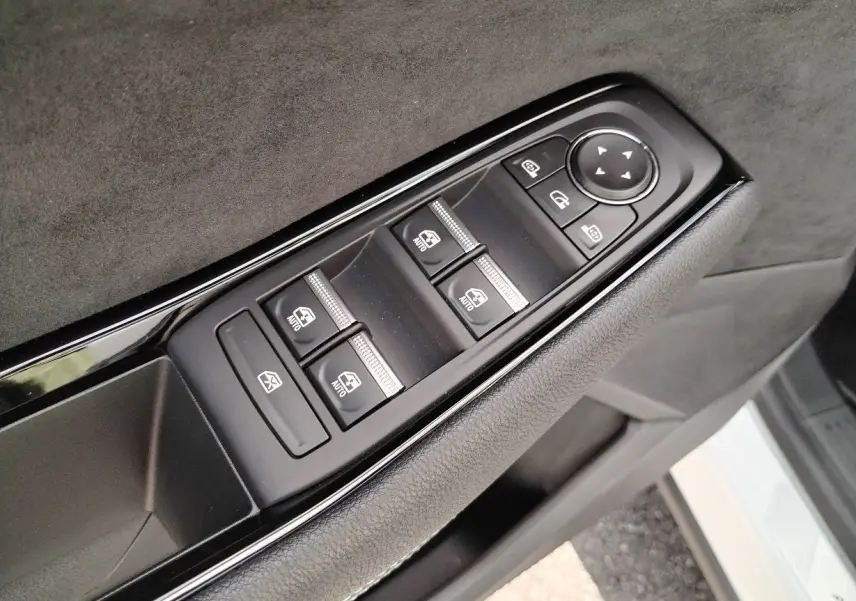 Gros plan sur les commandes des vitres et rétroviseurs côté conducteur du Renault Austral blanc nacré toit noir.