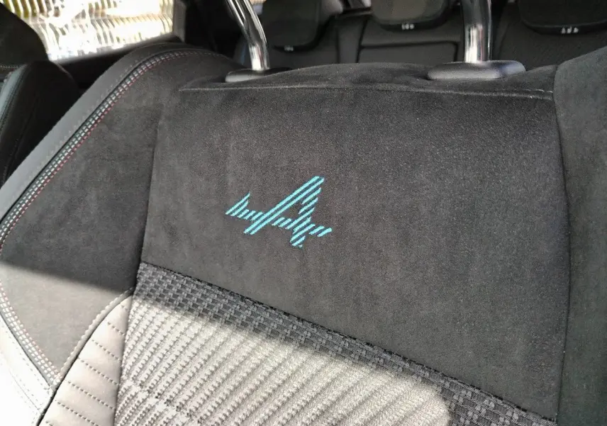 Gros plan sur le dossier de siège avant noir avec broderie bleue Esprit Alpine dans un Renault Austral 2025.