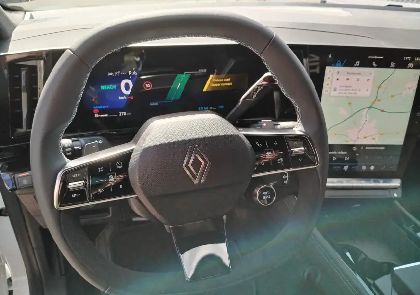 Vue rapprochée du volant noir du Renault Austral E-Tech avec tableau de bord numérique et écran tactile de navigation.