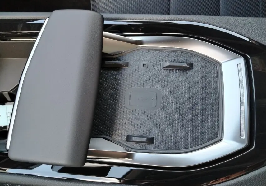 Gros plan sur la console centrale noire et argentée du Renault Austral E-Tech 2025 avec repose-bras rembourré.