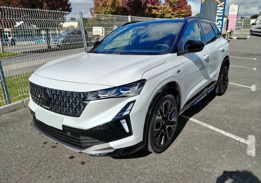 Renault Austral E-Tech blanc nacré avec toit noir, vue 3/4 avant droit, calandre et jantes noires distinctives.