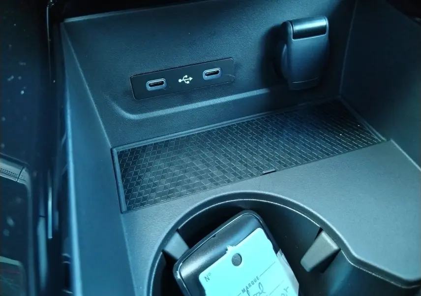 Prise USB double et prise 12V dans la console centrale noire du Renault Austral E-Tech hybride 2025.
