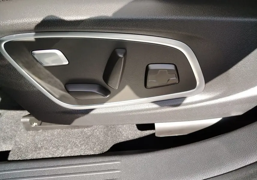 Détail des commandes électriques de réglage du siège côté conducteur du Renault Austral blanc nacré 2025.