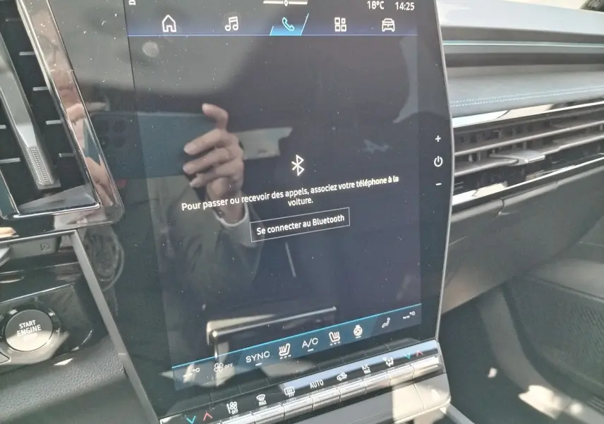 Écran tactile central du tableau de bord du Renault Austral blanc nacré, avec commandes climatisation et bouton start visible.