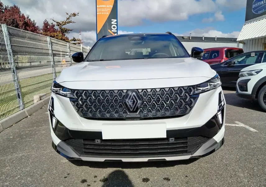 Vue frontale d'un Renault Austral blanc nacré avec toit noir, mettant en valeur sa calandre hexagonale distinctive.