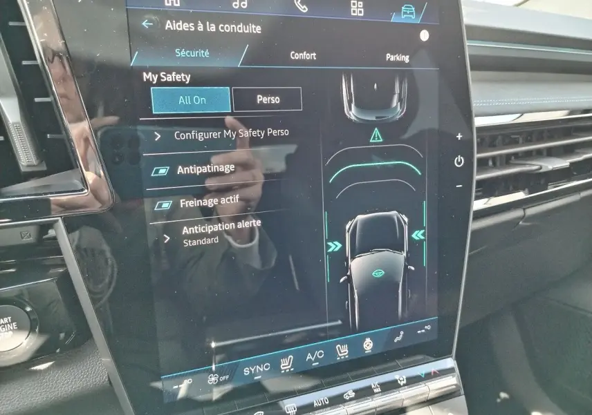 Écran tactile central du Renault Austral 2025 montrant les aides à la conduite et la vue du véhicule en plan vertical.