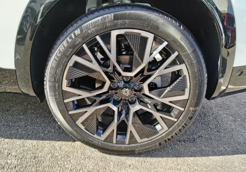 Gros plan sur la jante noire et argentée du Renault Austral blanc nacré avec pneu Michelin, côté avant droit.