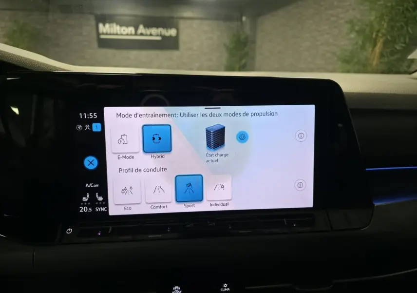 Écran tactile du tableau de bord de la Volkswagen Golf 1.4 eHybrid affichant les modes de conduite et propulsion hybride.