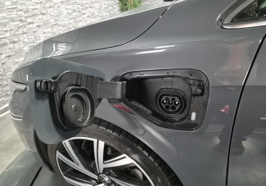 Prise de recharge ouverte côté avant gauche sur Volkswagen Golf gris avec jante alliage 18 pouces visible.