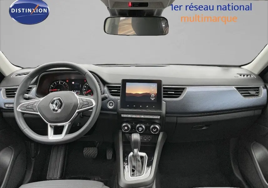 Vue intérieure frontale du tableau de bord noir du Renault Arkana 1.3 TCE 140 Evolution avec écran tactile central et volant multifonction.