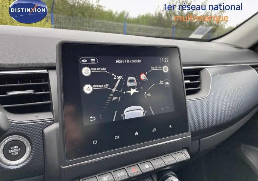 Vue intérieure centrée sur l'écran tactile du tableau de bord du Renault Arkana noir, affichant l'aide à la conduite.