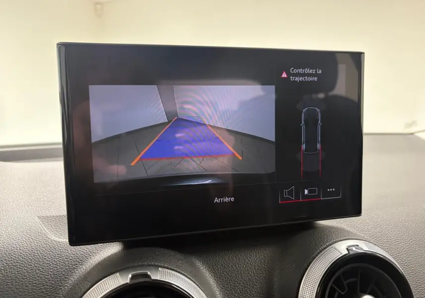 Écran intérieur montrant la caméra de recul et l'alerte de trajectoire de l'Audi Q2 Gris Daytona, version 2026.
