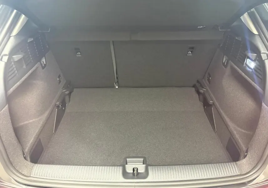 Coffre ouvert de l'Audi Q2 35 TFSI S Line 2026 en gris Daytona, montrant un espace de chargement propre et bien éclairé.