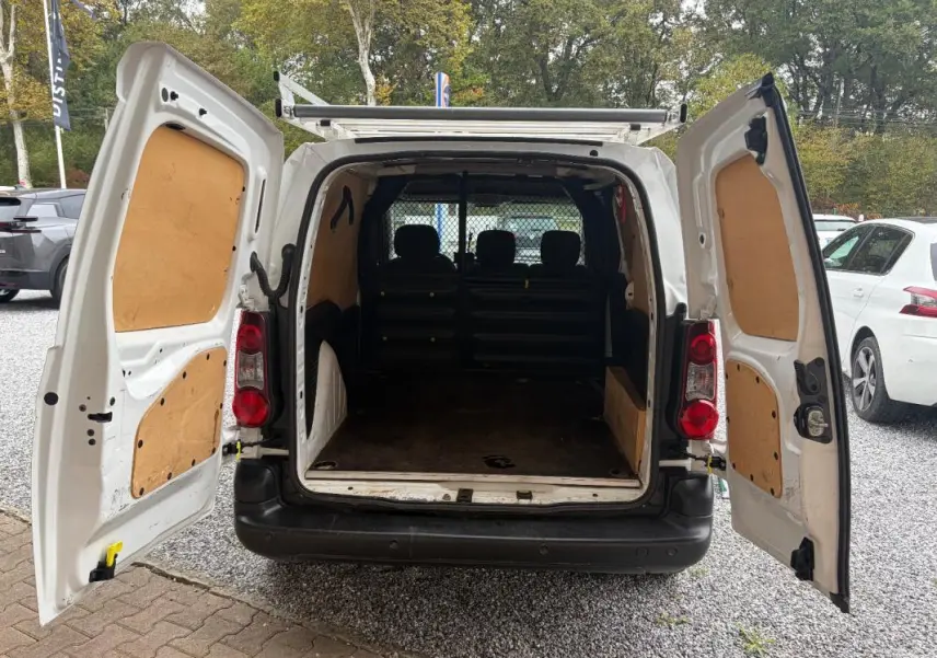 Vue arrière du Citroën Berlingo fourgon blanc 2018 avec portes ouvertes montrant l’espace de chargement vide et la cloison de séparation.