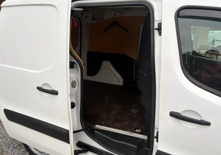 Vue latérale gauche du Citroën Berlingo blanc 2018 avec porte coulissante ouverte dévoilant l’espace de chargement vide.