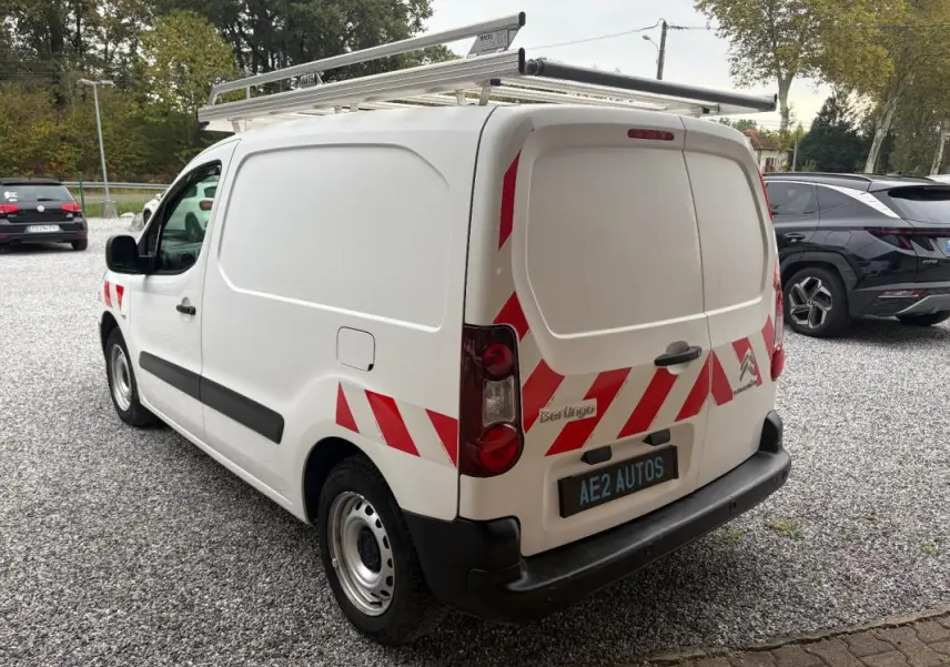Vue 3/4 arrière droite d’un Citroën Berlingo blanc 2018 avec bandes rouges réfléchissantes et galerie de toit.