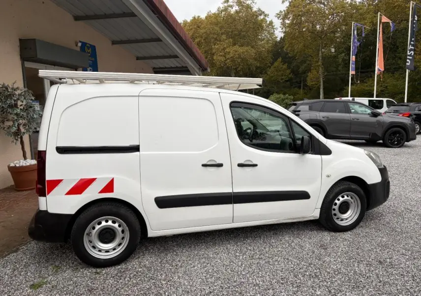 Vue de profil côté gauche d’un Citroën Berlingo blanc fourgon 2018 avec marquages réfléchissants rouges à l’arrière et galerie sur le toit.