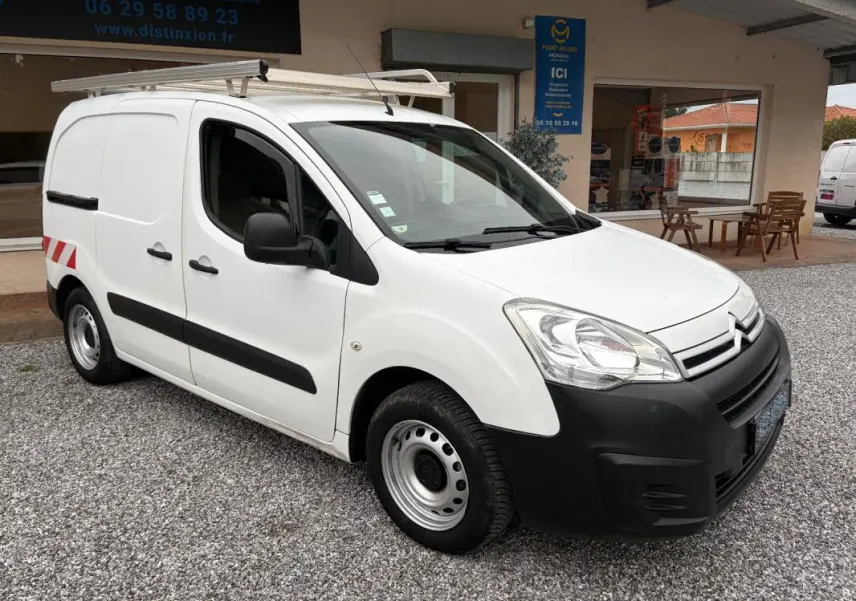 Citroën Berlingo Fourgon blanc en 3/4 avant droit avec galerie de toit et protections noires visibles.