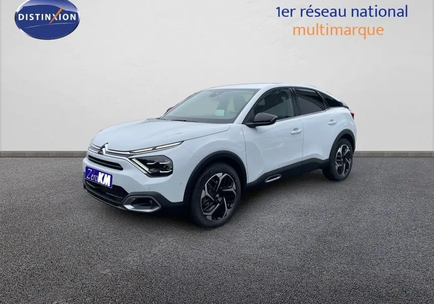 Citroën C4 blanc métal vue 3/4 avant droit, avec jantes noires et détails noirs contrastants sur carrosserie.