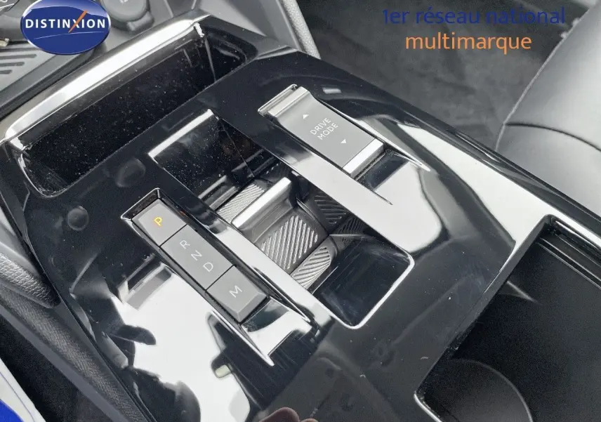 Gros plan sur la console centrale noire brillante de la Citroën C4 2024 avec commandes de boîte auto et mode de conduite.