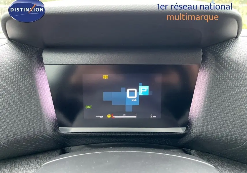 Affichage numérique du tableau de bord de la Citroën C4 blanche métal 2024, indiquant la vitesse à 0 km/h et le mode parking.