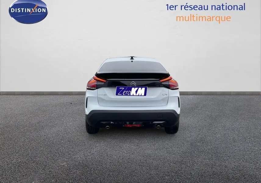 Vue arrière d'une Citroën C4 blanche métallisée 2024 avec feux arrière LED et double sortie d'échappement.
