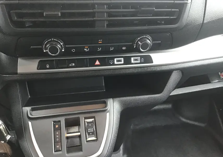 Vue rapprochée de la console centrale intérieure du Fiat Scudo Fourgon blanc, avec commandes climatisation et boîte automatique.