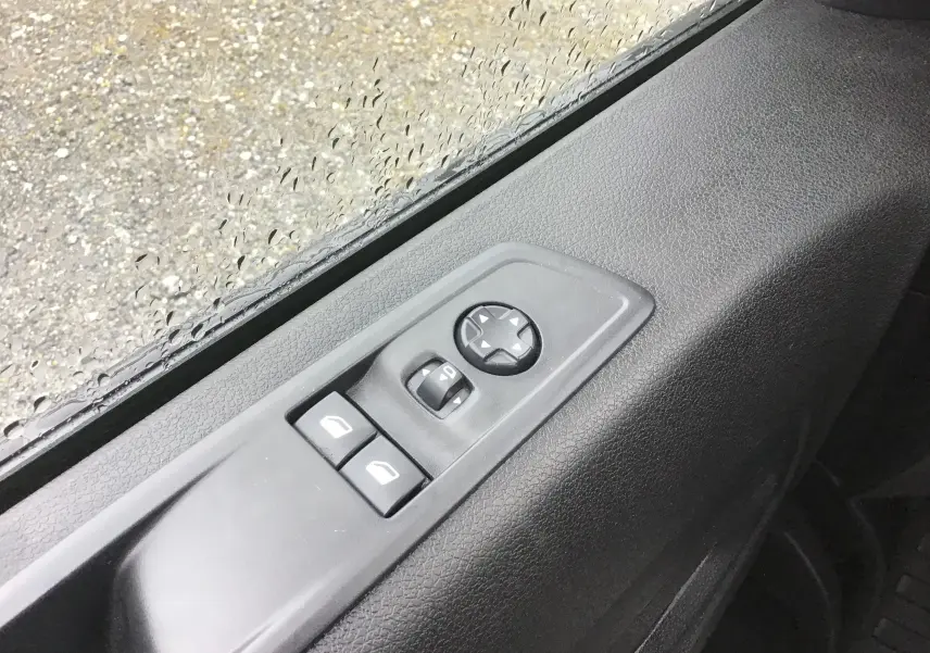 Gros plan sur les commandes électriques des vitres et des rétroviseurs sur la porte côté conducteur du FIAT Scudo Fourgon blanc.
