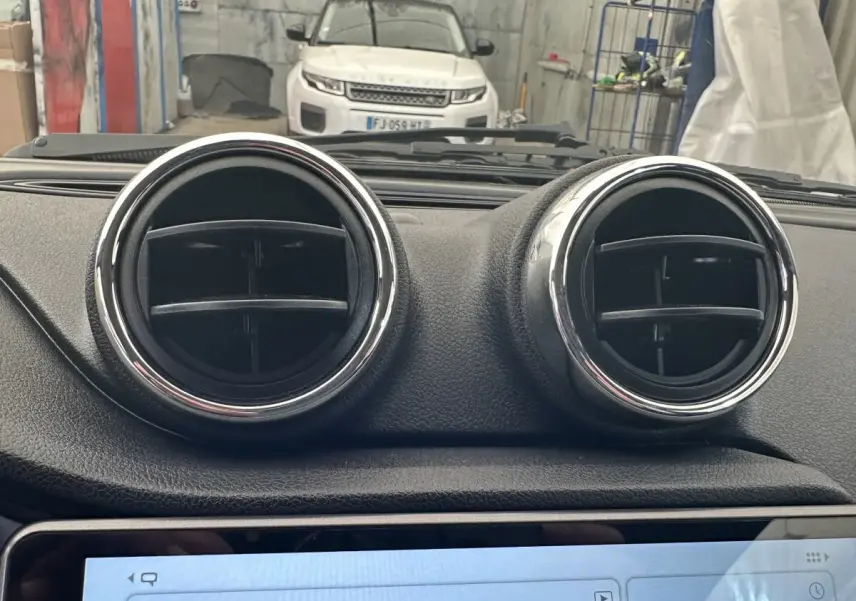 Vue intérieure centrée sur les deux aérateurs ronds du tableau de bord d'une Aixam Ambition 0.5 City GTO blanche.