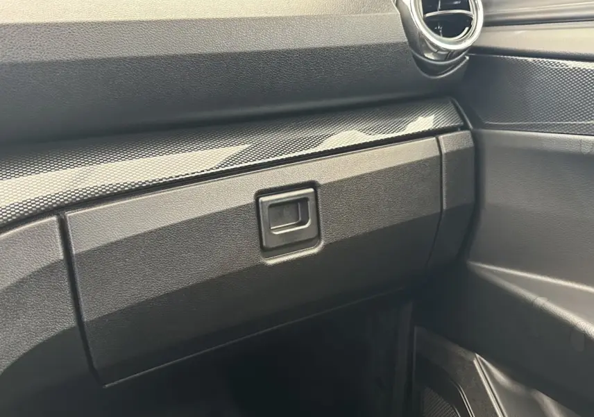 Détail de la boîte à gants et partie droite du tableau de bord noir de l'AIXAM AMBITION 0.5 CITY GTO 2026.