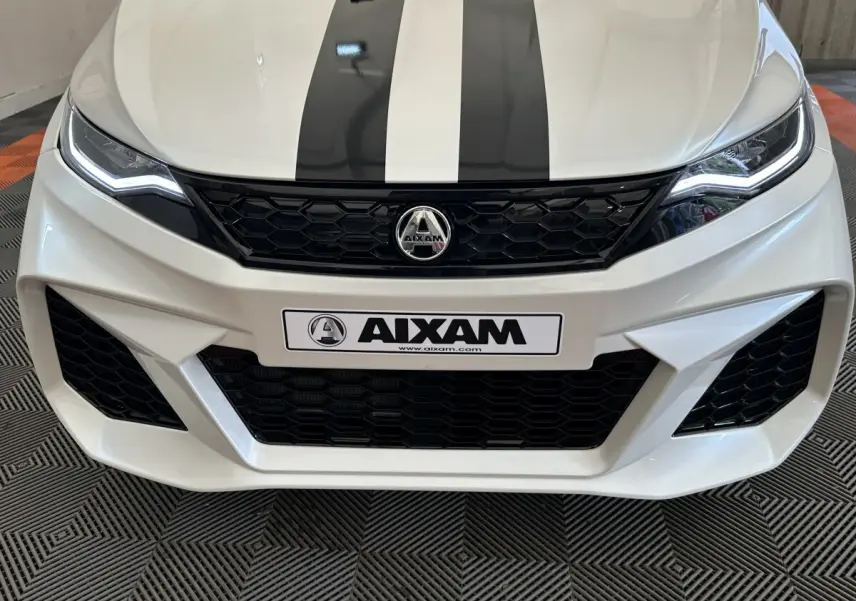 Vue avant rapprochée de l'AIXAM AMBITION 0.5 CITY GTO blanche avec bandes noires sur le capot et calandre noire.