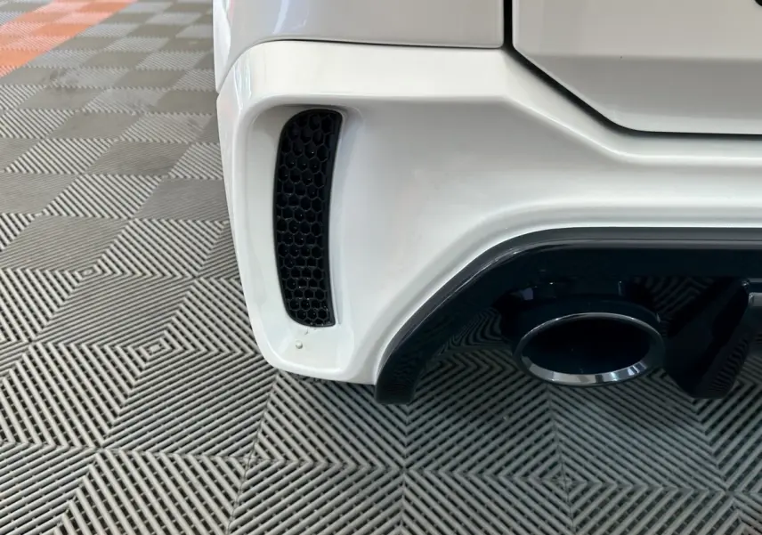 Gros plan sur l'échappement arrière droit blanc de l'AIXAM AMBITION 0.5 CITY GTO 2026 avec diffuseur noir.