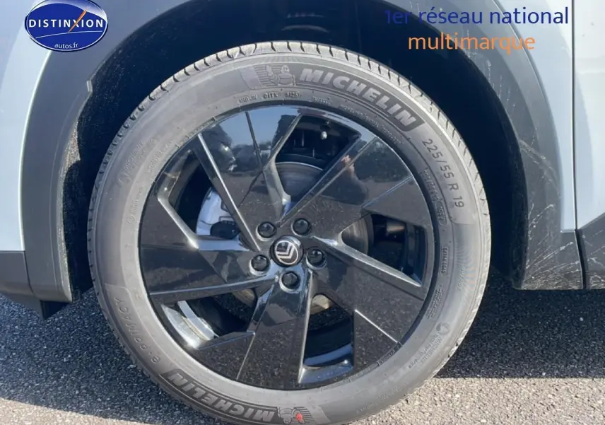 Gros plan sur la roue arrière droite noire et jante 19 pouces du Citroën C5 Aircross blanc 2026 hybride.