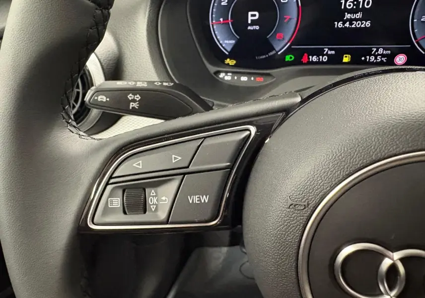 Gros plan sur le volant côté gauche de l'Audi Q2 35 TFSI 2026 avec commandes intégrées et tableau de bord numérique.
