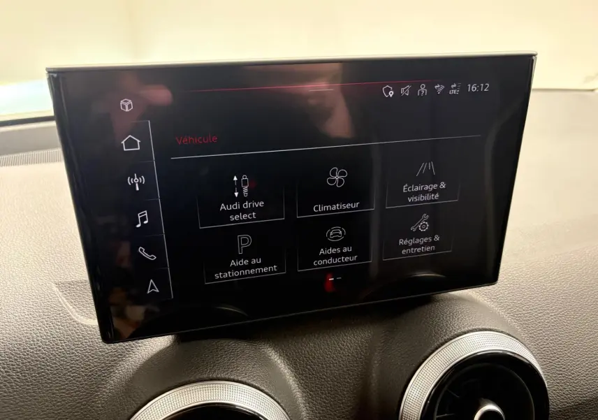 Écran tactile central de l'Audi Q2 35 TFSI 150 S Line 2026, affichant les réglages du véhicule, intérieur noir.