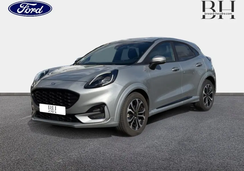 Ford Puma 2024 gris Solar métallisé en vue 3/4 avant droit, avec jantes alliage et calandre noire distinctive.
