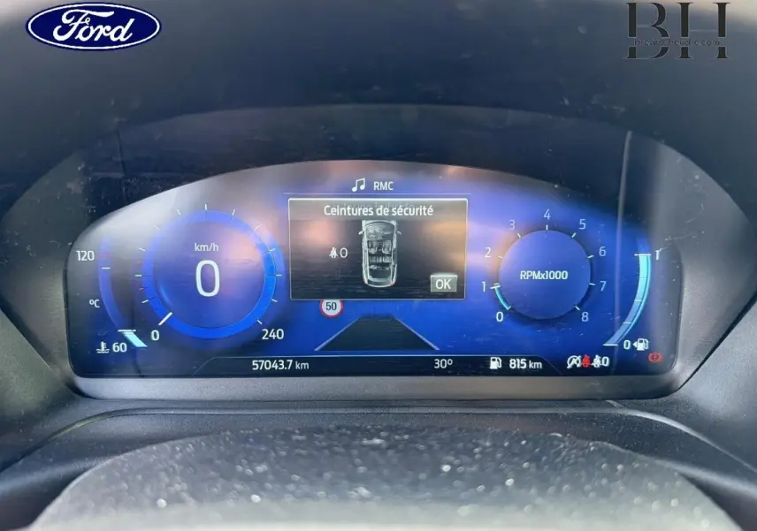 Gros plan sur le tableau de bord numérique bleu du Ford Puma 2024, affichant vitesse, compte-tours et alertes sécurité.