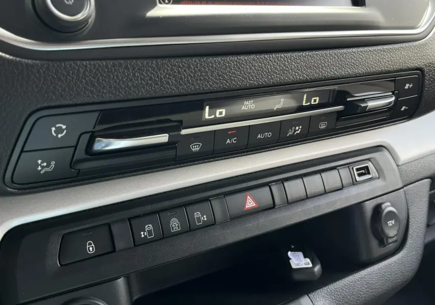 Tableau de bord du Citroën Spacetourer XL noir, montrant les commandes de climatisation et les boutons de portes électriques.