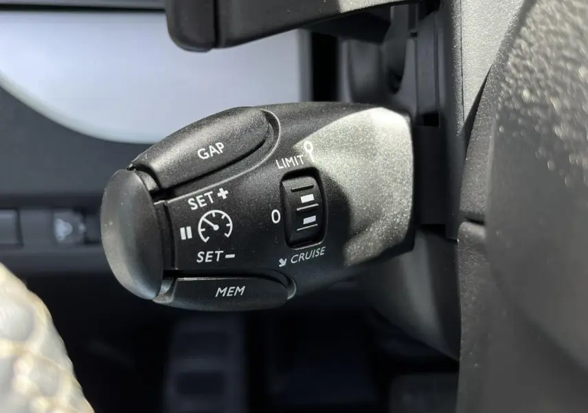 Gros plan sur la commande de régulateur de vitesse au volant du Citroën Spacetourer XL noir Perla 2024.