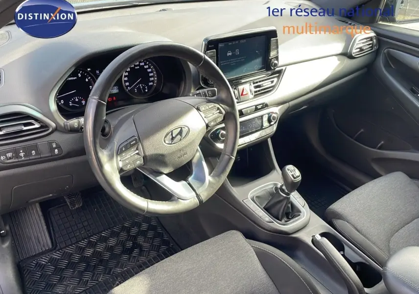 Vue intérieure côté conducteur du tableau de bord et console centrale d'une Hyundai i30 SW 2024 avec boîte manuelle.