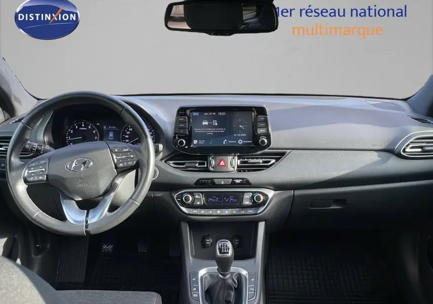 Vue intérieure frontale du tableau de bord de la Hyundai i30 SW 2024 avec volant multifonction et écran tactile central.