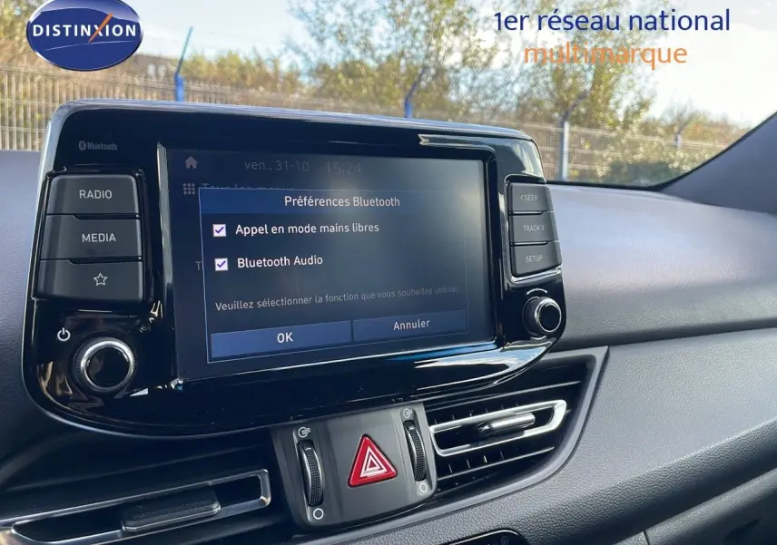 Tableau de bord de Hyundai i30 SW 2024 avec écran tactile affichant les préférences Bluetooth, ambiance intérieure gris noir.