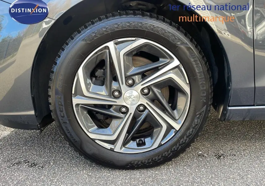 Gros plan sur la roue avant gauche de la Hyundai i30 SW 2024 en couleur Dark Knight Metal avec jante alliage moderne.